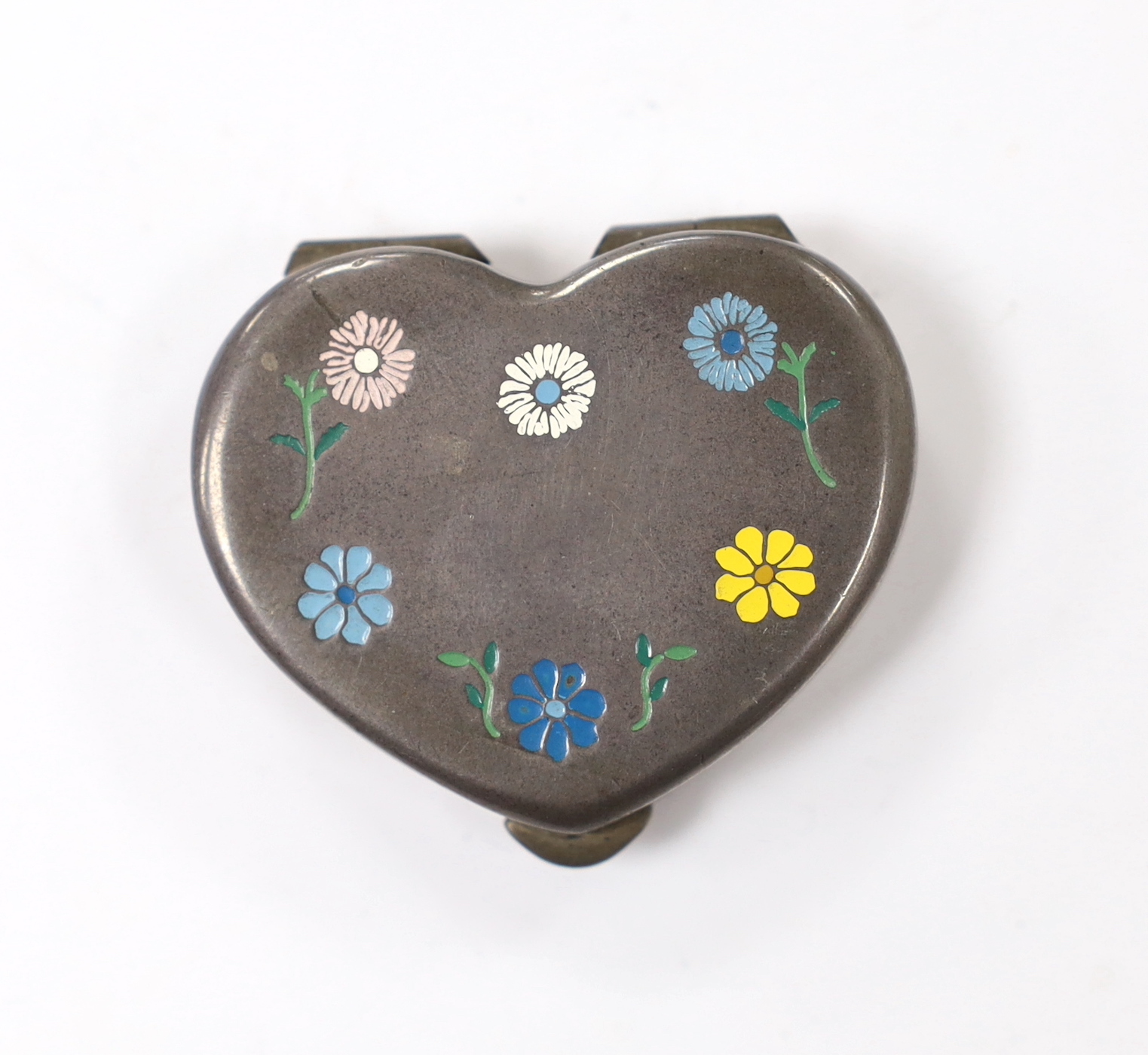 A 20th century Cartier sterling and enamel heart shaped pill box, decorated with flower heads, width 41mm.